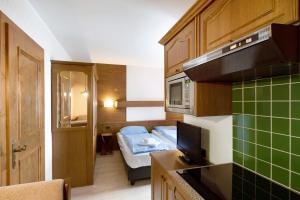 a small kitchen with a bed in a room at Casa San Marco n 9 in Livigno