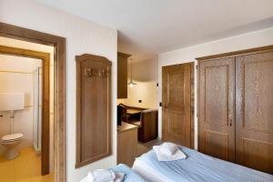 a bedroom with a bed and a bathroom with a toilet at Casa San Marco n 9 in Livigno