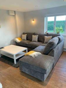 a living room with a couch and a coffee table at The Lodge - Dog Friendly Farm Cottage in Norwich