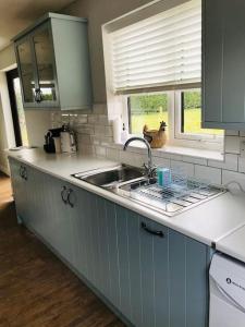 a kitchen counter with a sink and a window at The Lodge - Dog Friendly Farm Cottage in Norwich