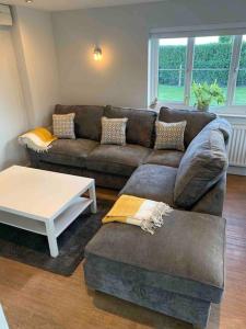 a living room with a couch and a coffee table at The Lodge - Dog Friendly Farm Cottage in Norwich