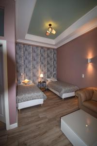 a bedroom with two beds and a couch at Connie's Apartments in Heidelberg