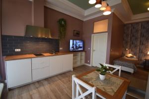 uma cozinha com armários brancos, uma mesa e um sofá em Connie's Apartments em Heidelberg