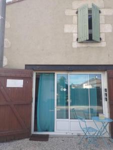 Puerta del patio con mesa y silla frente a un edificio en Au Clos des Figues, en Chambon