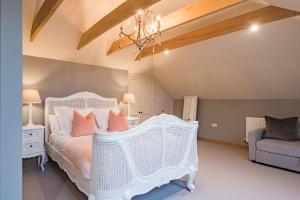 a bedroom with a white bed and a chair at The Dairy by Bloom Stays in Ulcombe