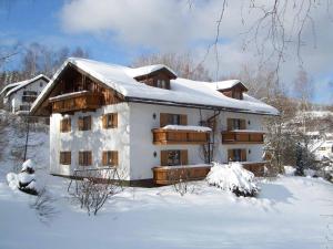 ein Haus mit Schnee auf dem Dach in der Unterkunft Ferienwohnungen Haus "Wildschütz" in Frauenau