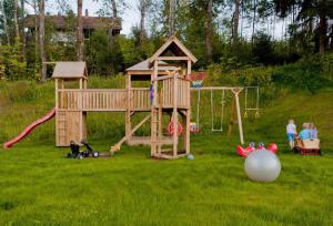 a childrens playground with a play set in the grass at Ferienwohnungen Haus "Wildschütz" in Frauenau