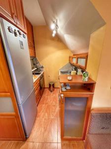 a kitchen with a stainless steel refrigerator and wooden cabinets at 20 OFF Sun Dance Apartment in Sofia