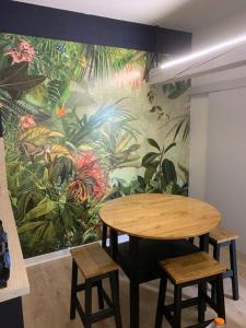 uma mesa e cadeiras num quarto com um mural em latypique family em Bourges