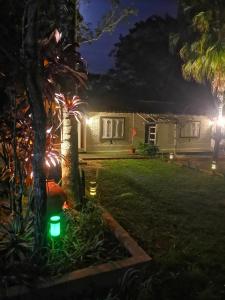 a house with lights in the yard at night at El Paraje Camping in Piribebuy