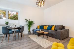 a living room with a couch and a table at Modernes Apartment – 2 Boxspringbetten – Zentral in Kassel