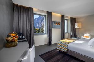 a hotel room with a bed and a window at Lido Palace - The Leading Hotels of the World in Riva del Garda