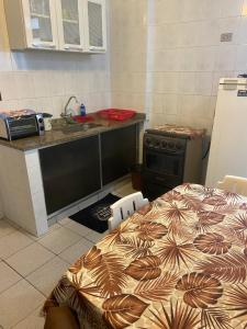 een keuken met een bed, een wastafel en een fornuis bij Apartamento CF BRAGA in Cabo Frio