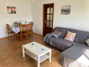 un soggiorno con divano e tavolo di MARTSARAs PLAYA SARDINA a Sardina