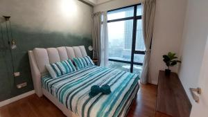a bedroom with a bed with two blue shoes on it at Majestic Apartment KLCC in Kuala Lumpur