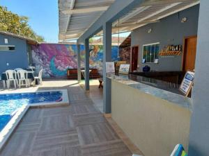 a swimming pool with a bar next to a house at Casa com Piscina e 3 Quartos Climatizados 8km do Centro in Palmas