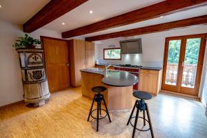 uma cozinha com um balcão e bancos num quarto em Traditional Chalet with some luxurious features em Troistorrents