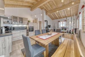 a kitchen with a wooden table and chairs at Pension und Ferienchalets Zum Lebzelter in Freyung
