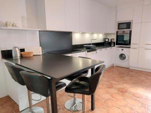 uma cozinha com uma mesa preta e cadeiras pretas em Maison avec vue imprenable em Châteauneuf