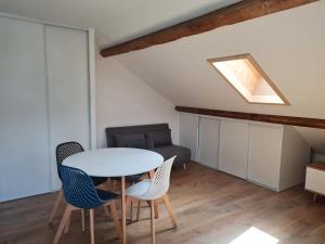 a room with a table and chairs and a couch at Nid douillet proche des pistes avec vue montagne in Saint-Gervais-les-Bains