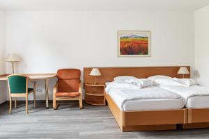 um quarto de hotel com duas camas e uma secretária em Löwen Pension em Unterlüß