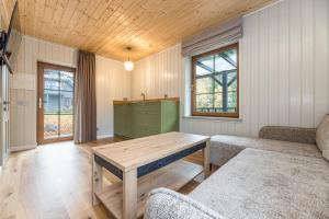 a living room with a wooden table and a couch at Želvė Village & SPA 