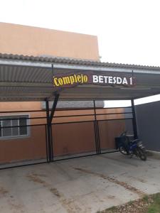 ein Motorrad, das unter einem Schild an einem Gebäude geparkt ist in der Unterkunft Complejo Betesda 1 in Federación