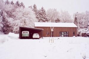 une grange avec une voiture garée dans la neige dans l'établissement Wäller Haus - Modern villa with fireplace & large natural garden, à Breitscheid