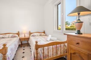 - une chambre avec 2 lits et une fenêtre dans l'établissement Torres Sureda, à Cala Blanca