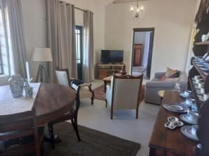 a living room with a table and chairs and a television at Prinspoort Klein Karoo Stay in Ladismith
