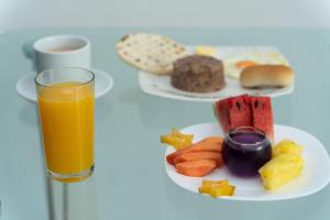 un plato de comida y un vaso de zumo de naranja en Hotel Aires del Quindío Armenia, en Armenia