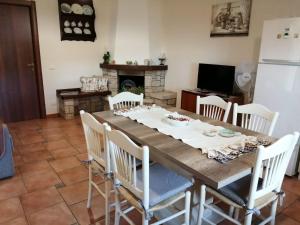 a dining room with a wooden table and chairs at Villa Etna Masi' in Milo