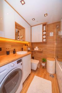 a bathroom with a washing machine and a toilet at Beni Apartment in Bar