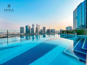 een zwembad met een skyline van de stad op de achtergrond bij Mira Holiday Homes - Lovely 1 bedroom apartment in Downtown in Dubai