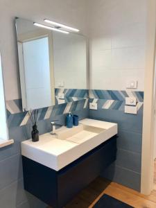 La salle de bains est pourvue d'un lavabo et d'un miroir. dans l'établissement GIULIVETO Bed and Breakfast, à Foligno