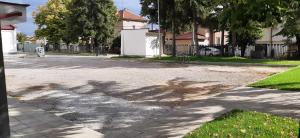 a street with a tree shadow on the road at Hostel Iliana Общежитие Илияна in Elin Pelin