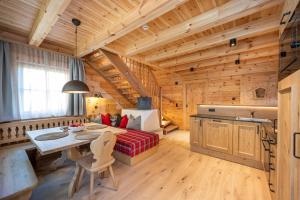 Cabaña de madera con mesa y sofá en Dorf-Chalets Filzmoos mit Sauna, en Filzmoos
