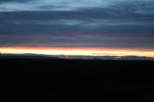 a sunset in the middle of a field at Grímstunga Guesthouse road 864 Hólsfjöllum in Víðirhóll