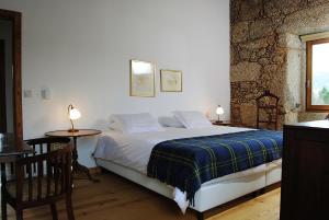 a bedroom with a bed and a table with a chair at Quinta de Seves in Covilhã
