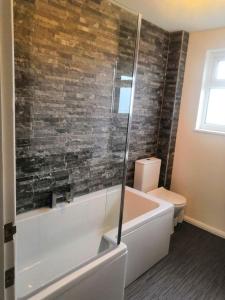 a bathroom with a toilet and a tub and a sink at Number 49 in Great Torrington +18 photos