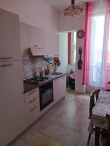 a kitchen with white cabinets and a stove top oven at Casa GIULIVA in Alessandria