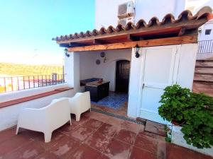 a room with a balcony with a door and chairs at Casa Jaruf CENTRO HISTÓRICO Parking Gratuito Patio petfriendly in Arcos de la Frontera