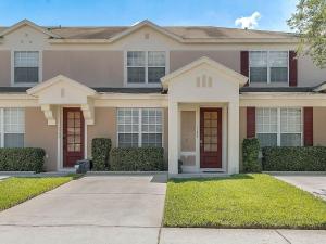 a large house with red doors and grass at Veteran Owned 3bdr/3 bath Townhouse w/WiFi 3mi to Disney - Fall/Winter Specials in Kissimmee