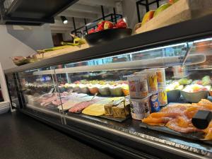 une vitrine remplie de nombreux types de denrées alimentaires différents dans l'établissement Hostellerie Klokhof, à Courtrai