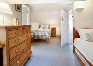 1 dormitorio con 2 camas y vestidor en Letterbox Cottage en Chipping Campden