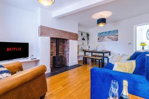 a living room with a blue couch and a fireplace at Lovely 2-bed house in Chester by 53 Degrees Property, Ideal for Couples & Small Groups, Amazing Location - Sleeps 4 in Hough Green