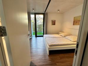 a bedroom with a bed and a door leading to a doorway at Ferienwohnung SEE UND MEHR in Stetten