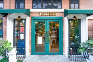 a store with a blue door on a brick building at The Riche Boutique Hotel Don Mueang Airport in Bangkok