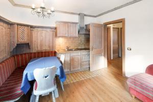 eine Küche mit Holzschränken, einem blauen Tisch und Stühlen in der Unterkunft Casa Li Roina n 43 in Livigno