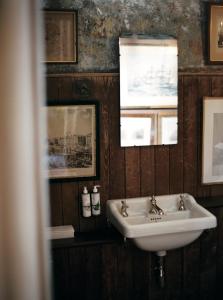 a bathroom with a sink and pictures on the wall at St Giles House Accommodation in Wimborne Saint Giles